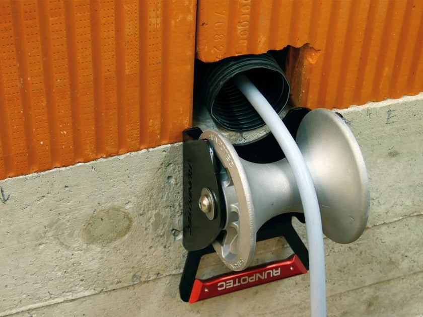 RUNPOTEC cable guide roller - shaft is ideally suited for mounting in shafts to pull cables gently around corners with the least possible resistance. Example photo of shaft roller attached to a concrete wall